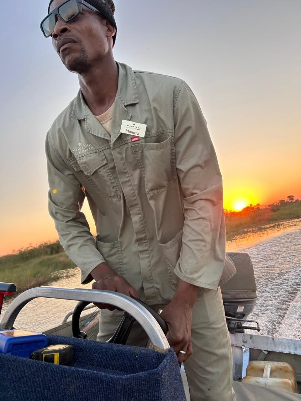 Boat guide in uniform at the helm during a sunset cruise near Samonyana Private Island