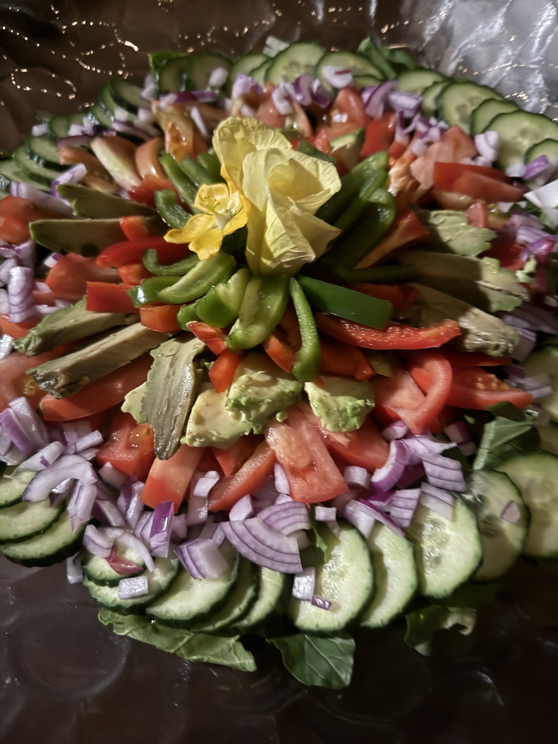Elaborately arranged salad platter of fresh tomato, cucumber, avocado and onion garnished with an edible flower at Samonyana Private Island.
