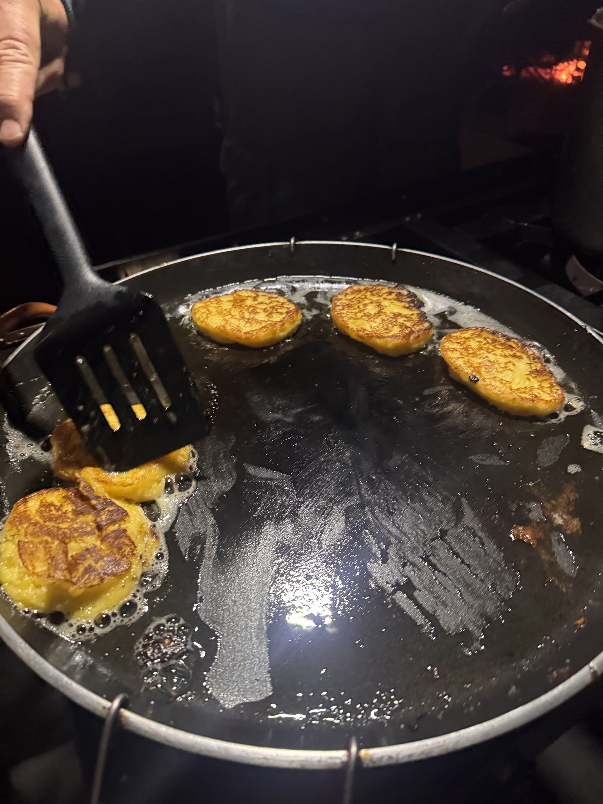 Golden fritters frying in a pan during a bush dinner at Samonyana.