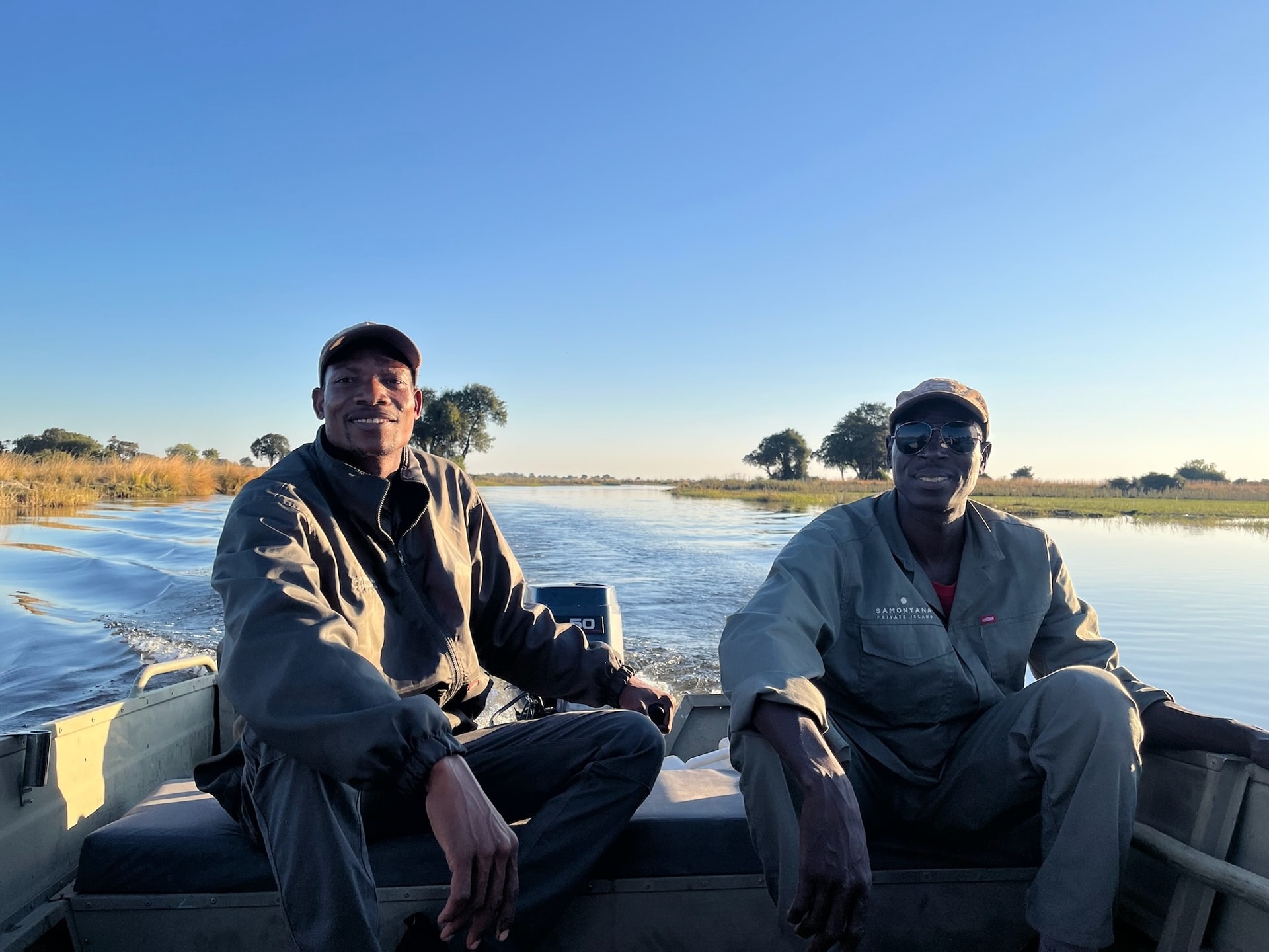 A family at the water's edge at Samonyana at sunset