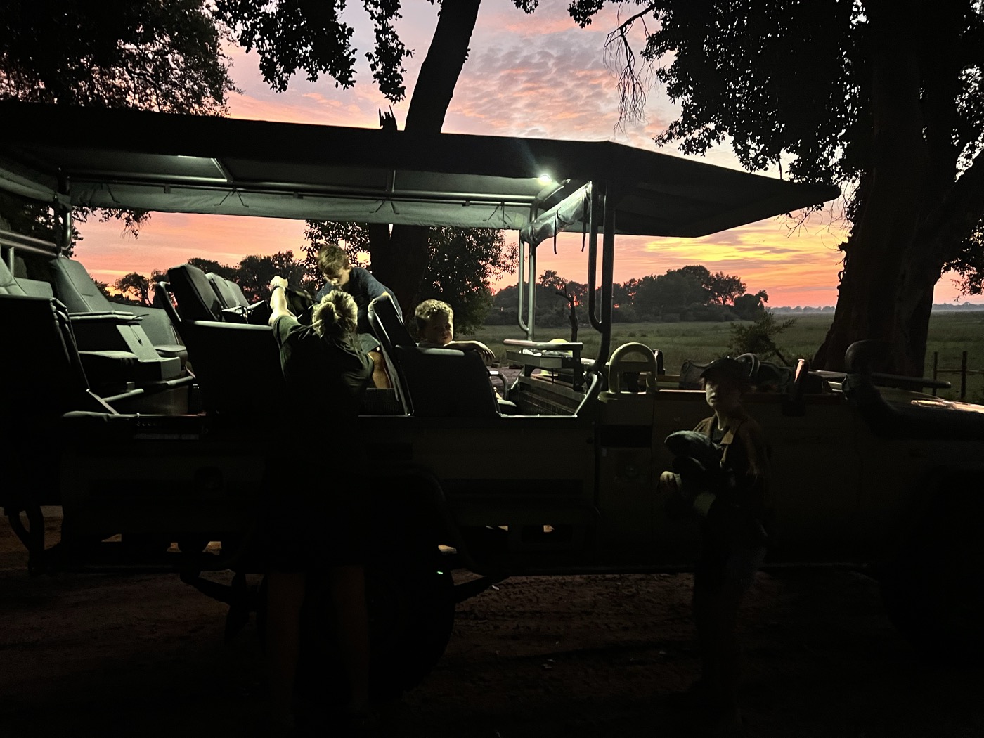 Dawn game drive on the Okavango Delta — guests watching the sunrise from a safari vehicle at Samonyana